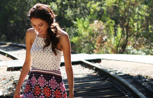 Girl in a Summer dress walking over training tracks